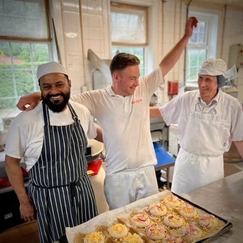 Bakers in the Hockley Heath bakehouse with a tray of fresh bakes